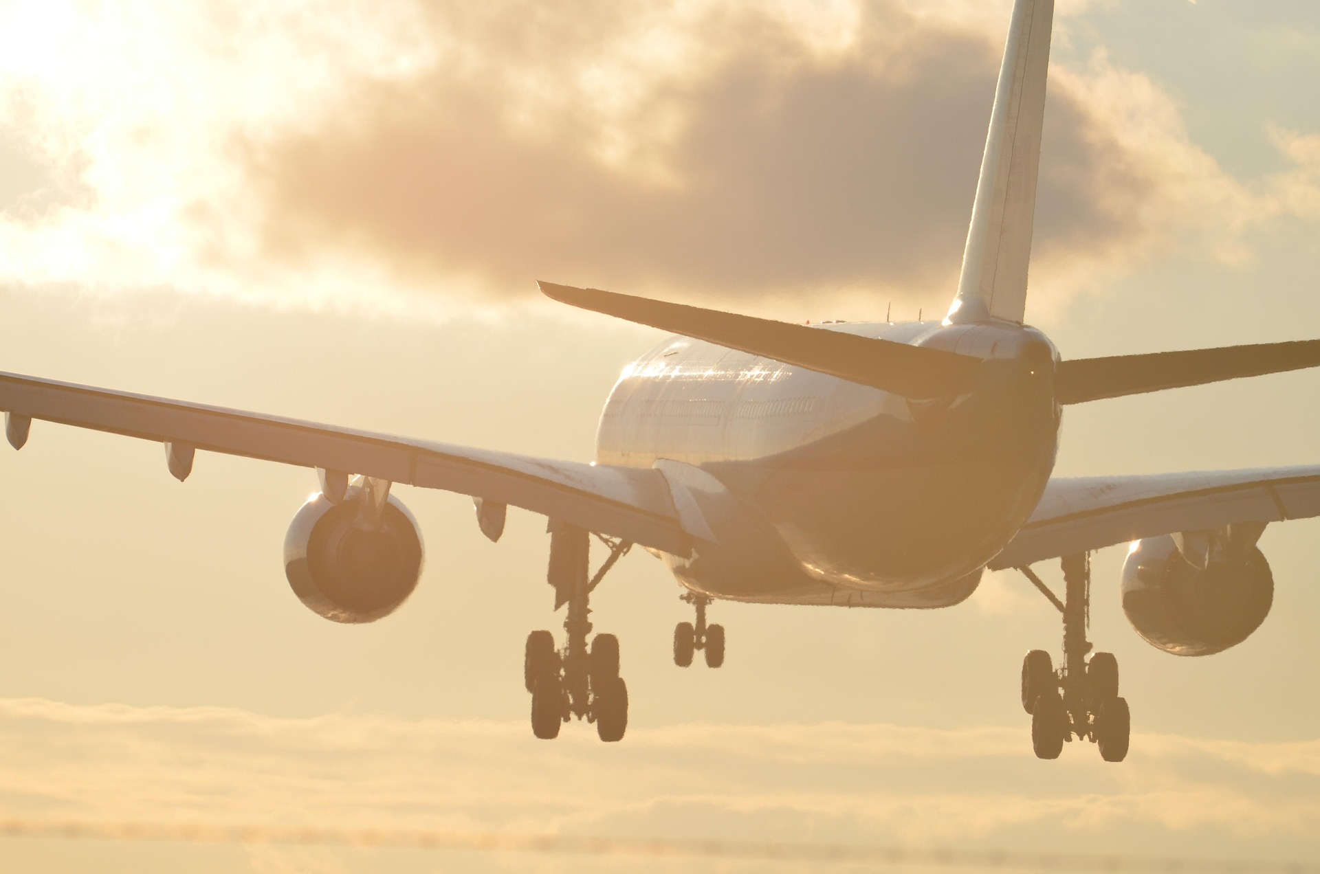 Flugzeug fliegt entgegen Sonnenuntergang